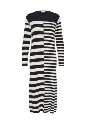 Vestido largo acanalado en negro y crema, con franjas horizontales alternas y un patrón degradado. Escote redondo y mangas largas.