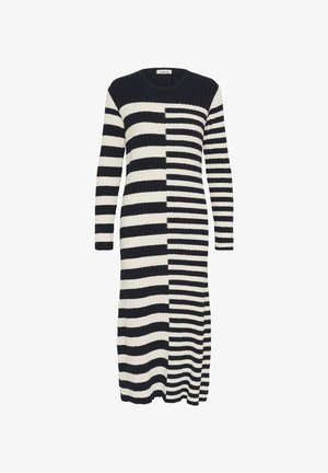 Robe longue côtelée en noir et crème, présentant des rayures horizontales alternées et un motif dégradé. Col rond et manches longues.