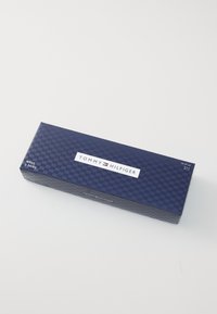 Marineblaues rechteckiges Kästchen mit einem karierten Muster, das ein weißes Etikett trägt, auf dem "TOMMY HILFIGER" steht und "HERREN 3 PAAR" anzeigt.