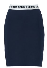 Námořnická sukně s přiléhavým designem, se širokým elastickým pasem zdobeným nápisem "TOMMY JEANS." Hladká, pružná textilie.