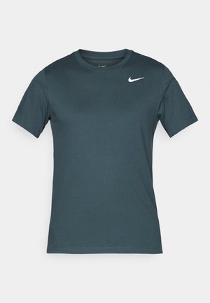 Camiseta atlética de manga corta hecha de tela verde azulado, con cuello redondo, presenta un pequeño logo blanco de Nike en el lado izquierdo del pecho. Textura suave.