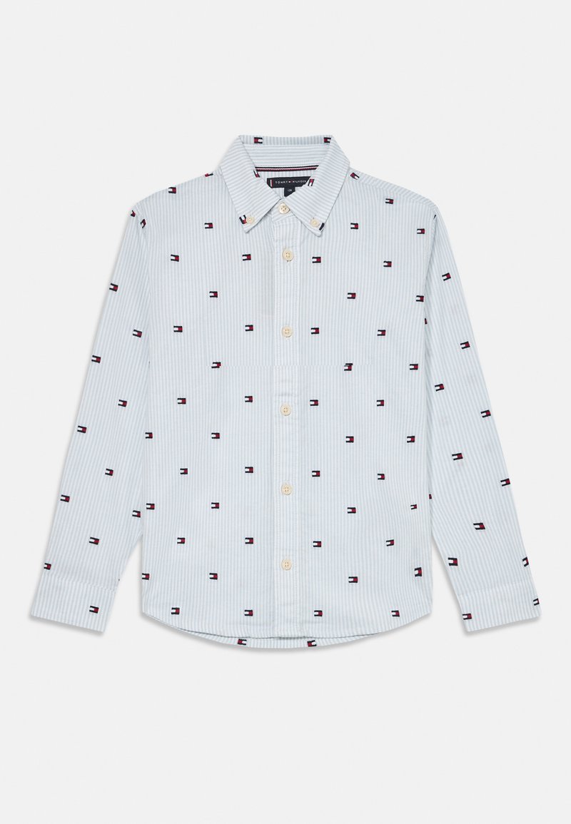 Knappskjorte i lyseblå med hvite striper. Merkbar rød og marineblå logo-mønster gjennomgående. Laget av et glatt stoff, med klassisk krage.