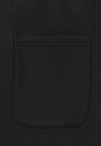 Tissu noir avec une poche plaquée rectangulaire cousue, présentant des coutures doubles et des coins inférieurs arrondis.