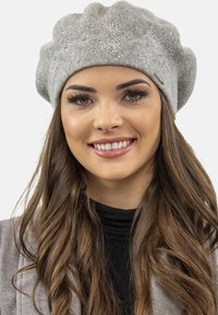 Beret gris hecho de lana suave, con embellishments de cuentas. Textura cálida y forma redonda con parte superior recogida.