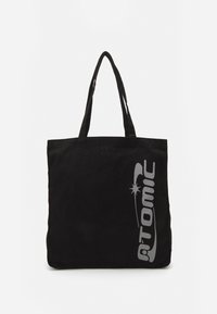 Sac tote noir avec le logo "ATOMIC" gris. Fabriqué en tissu durable avec deux anses. Forme rectangulaire avec une texture simple.