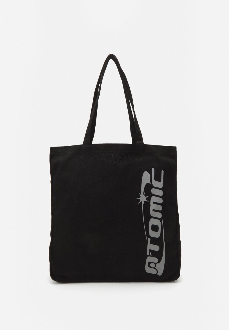 Sac tote noir avec le logo "ATOMIC" gris. Fabriqué en tissu durable avec deux anses. Forme rectangulaire avec une texture simple.