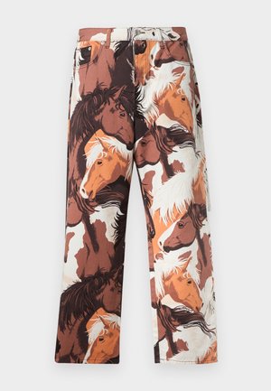 Bukser med et gentaget mønster af hestehoveder i nuancer af brun, hvid og orange, lavet af et glat stof med lige ben.