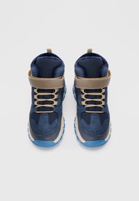 Marinblå högskaftade sneakers i mocka och syntetmaterial, med ett beige rem, snörning och blå gummisula.