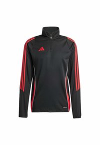 Camiseta deportiva de manga larga negra con rayas rojas en las mangas, cuello con cremallera en la parte delantera y logo rojo en el pecho izquierdo.