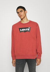 Felpa rossa in cotone, con logo nero Levi's sul petto, colletto rotondo, maniche lunghe e polsini a costine.