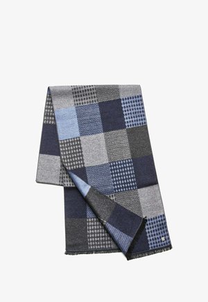 Multicolored plaid scarf featuring shades of blue and grey. Made of textured fabric with varied patterns and fringed edges.
