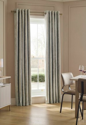 Hellgraue Vorhänge hängen an einem Fenster in einem beigen Zimmer mit einem Esstisch, Stühlen und zwei Gläsern Rotwein.