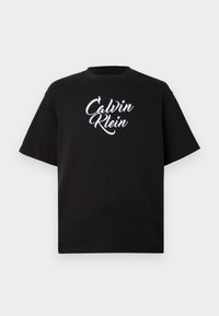 Black cotton t-shirt with a crew neck and short sleeves featuring a white cursive "Calvin Klein" logo across the chest.