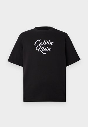 Juodas medvilninis marškinėliai su apvalia iškirpte ir trumpomis rankovėmis, puošti balta kreivai rašyta "Calvin Klein" logotipu per krūtinę.