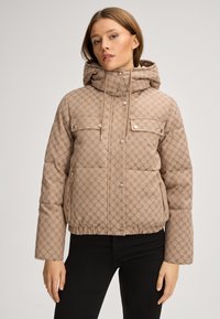 Beżowa kurtka puchowa z geometrycznym wzorem, z kapturem, suwakiem z przodu, zatrzaskami i dwoma kieszeniami na piersi. Teksturowana tkanina z elastycznym dołem.