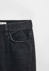 Vaqueros de mezclilla negros con un corte estándar, con una cintura recta, bolsillo frontal y costuras en contraste a lo largo de los bordes.