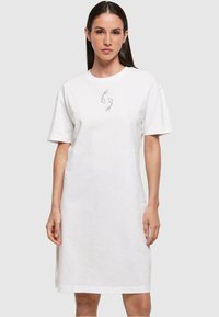 Robe t-shirt en coton blanc avec des manches courtes, coupe décontractée, présentant un graphique de main gris minimaliste au centre. Design épuré et sans ornements.