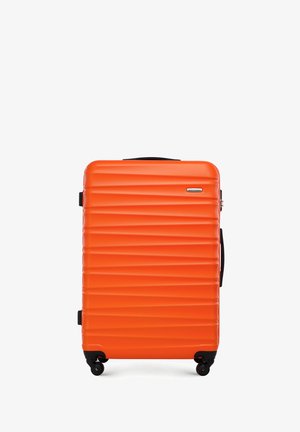 Hartschalentrolley in Orange mit geriffeltem Design, schwarzen Rollen, einem Oberhandgriff und einem eleganten Schlossmechanismus. Robustes Material, modernes Design.