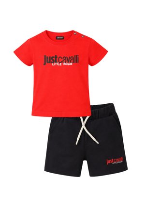 Maglietta rossa a maniche corte con la scritta "Just Cavalli Little Rogue" abbinata a pantaloncini neri con vita elastica, coulisse bianca e scritta coordinata.