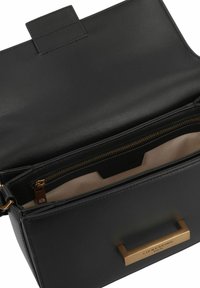 Black leather handbag with a smooth texture, featuring a gold rectangular handle and an interior zippered pocket. Magnetic snap closure.