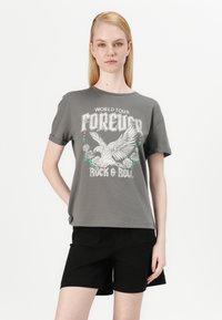T-shirt en coton gris à manches courtes, avec un imprimé graphique représentant un aigle, des roses et le texte "WORLD TOUR FOREVER ROCK & ROLL."