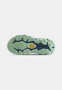 Semelle de chaussure avec une base bleu navy, des crampons en caoutchouc vert texturé, et un logo Vibram jaune proéminent au centre.