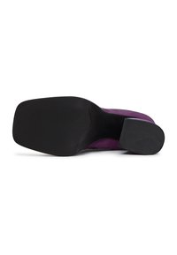 Violetti mokkanahkakengät korolla, joissa on sileä musta kumipohja, pyöristetty varvas ja teksturoitu pinta paremman pidon saavuttamiseksi.