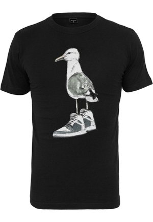 T-shirt in cotone nero con una grafica di un gabbiano che indossa sneakers. Il design include texture ad acquerello con tonalità di grigio e bianco.