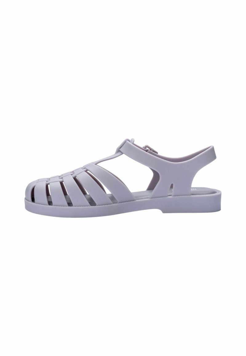 Sandal in plastica grigia con un design aperto caratterizzato da ritagli orizzontali e verticali, una cinghia posteriore e una suola piatta.