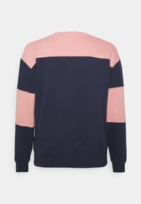 Granatowy sweter z bloku świetlnym różowym na ramionach i środkowej części rękawów, wyeksponowany z tyłu na jednolitym tle.