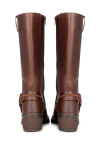 Botas de cuero marrón hasta la rodilla con una textura suave, cremalleras en los laterales y una correa decorativa alrededor del tobillo. Diseño de tacón apilado.