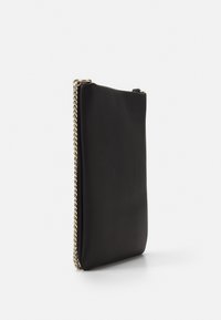 Černá kožená kabelka s hladkou texturou, s řetízkovým akcentem po straně a štíhlým, obdélníkovým tvarem. Minimalistický design.