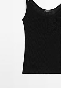 Schwarzes geripptes Tanktop aus leichtem Material, mit verstellbaren Trägern und einem strukturierten Blumenmuster auf der Vorderseite.