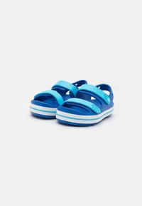 Sandalias azules con dos correas ajustables, plantilla texturizada y acentos blancos en la suela, fabricadas con material ligero y flexible.