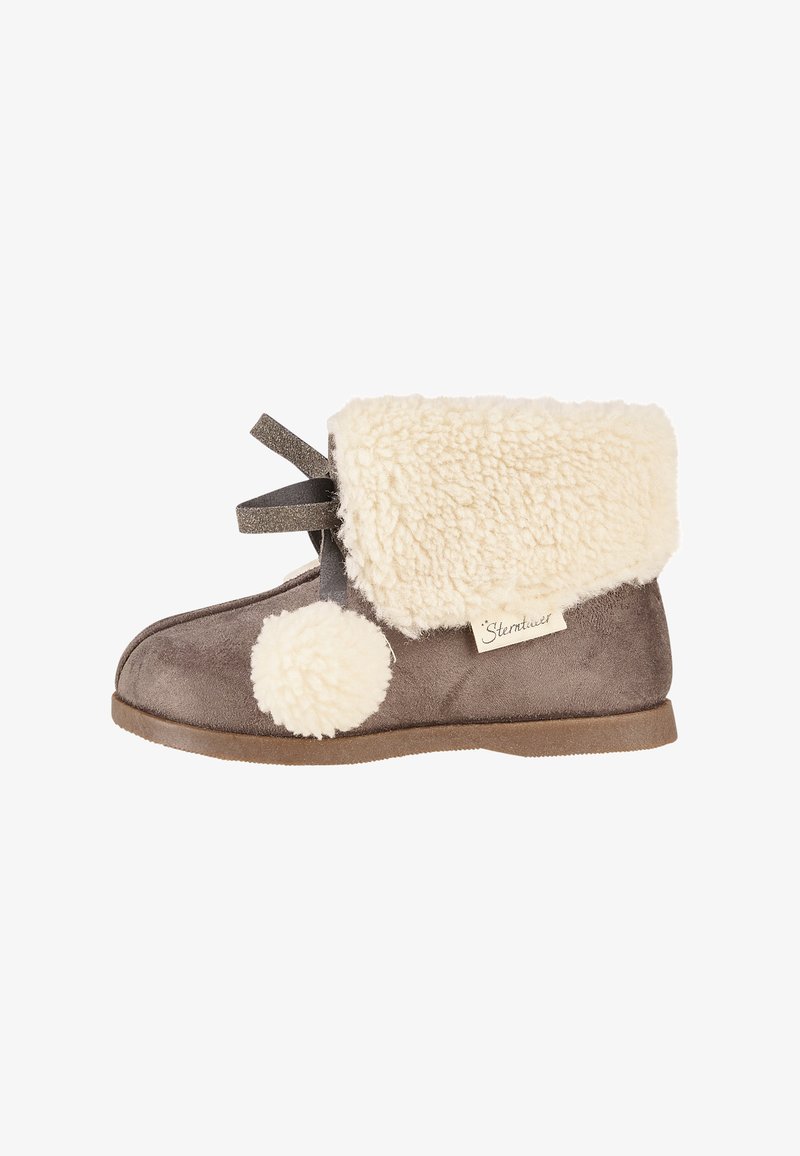 Braune Wildlederstiefel mit einem flauschigen, cremefarbenen Schaffellsaum und Pompon-Detail. Verfügt über eine flache Sohle und ein dekoratives graues Band.