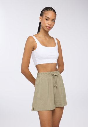 Top a fascia bianca con spalline larghe abbinato a pantaloni corti verde oliva chiaro con vita elasticizzata e dettagli con cordoncino.