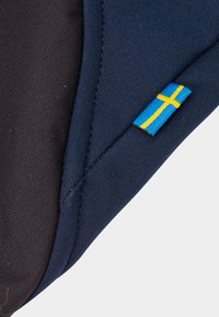 Navy fabric with a textured pattern, featuring a small Swedish flag patch in blue and yellow. The design includes contrasting black edges.