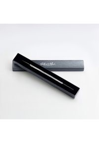 Bracciale d'argento con piccoli pietre quadrate all'interno di una scatola nera rettangolare. La scatola presenta una superficie texturizzata e un marchio argentato.