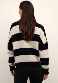 Maglione lavorato a maglia con ampie strisce blu navy e crema, forma oversize, spalle basse e polsini a coste, realizzato in morbido materiale testurizzato.