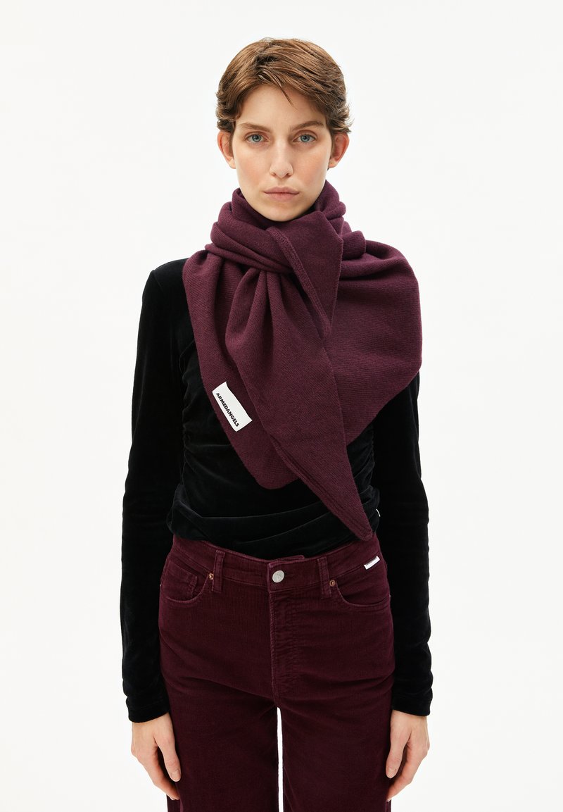 Écharpe bordeaux en tissu doux, drapée élégamment autour du cou. Texturée avec un motif subtil, étiquette de marque visible.