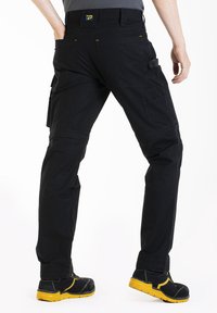 Pantalons cargo noirs avec plusieurs poches, jambes droites, coutures renforcées et détails de surpiqûres jaunes. Tissu léger et durable.