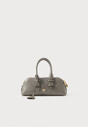 Sac à main en cuir gris avec une forme structurée, double poignées, accents en métal doré et logo décoratif. Fermeture à glissière et bandoulière amovible incluses.
