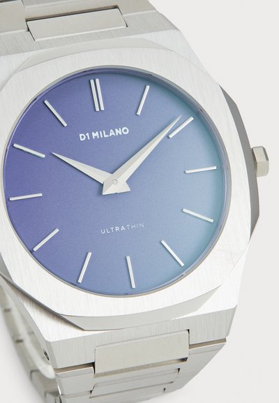 Ezüst rozsdamentes acél óra nyolcszögletű számlappal, amely fokozatosan világoskék árnyalatot mutat, és vékony ezüst órajelzőkkel rendelkezik. Modell neve: D1 MILANO ULTRATHIN.