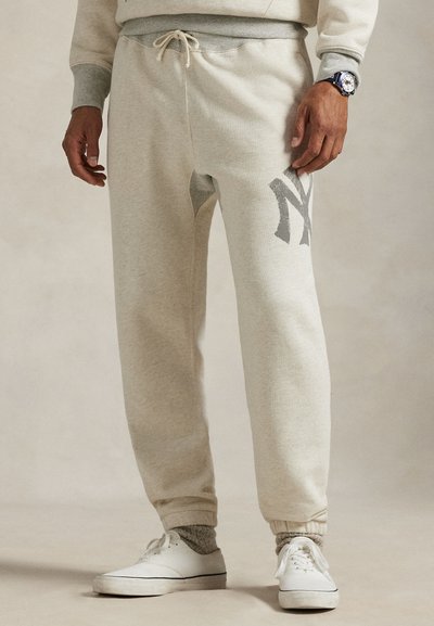 Kremfargede joggebukser med grå detaljer, som har elastisk midje, justerbar snor og brodert logo på benet.