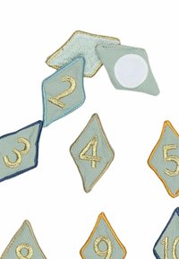 Fabric embroidered number patches in light green and blue, shaped as diamonds and triangles, featuring gold thread for numbers and accents.