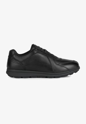 Zapatilla negra de cuero con un acabado suave, diseño de cordones, cuello acolchado y suela de goma negra acolchada con un patrón texturizado.