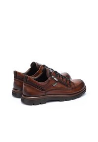 Chaussures en cuir marron avec un bout arrondi, un léger éclat et des accents texturés. Dotées d'un système de laçage et d'une semelle en caoutchouc noir pour une meilleure adhérence.