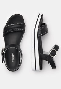 Sandalias de cuero negro con dos correas anchas que presentan acentos plateados, hebilla ajustable y suela de goma blanca. Diseño minimalista con un enfoque en la comodidad.