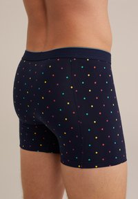 Tengerész kék boxer alsó, rugalmas anyagból készült, multiszínű pöttyös mintával, kényelmes derékkal és testhezálló kialakítással.