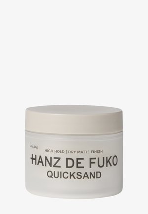 Glas med Hanz de Fuko Quicksand hårstylingsprodukt med stærkt hold og tør mat finish, 2 oz beholder med beige låg.